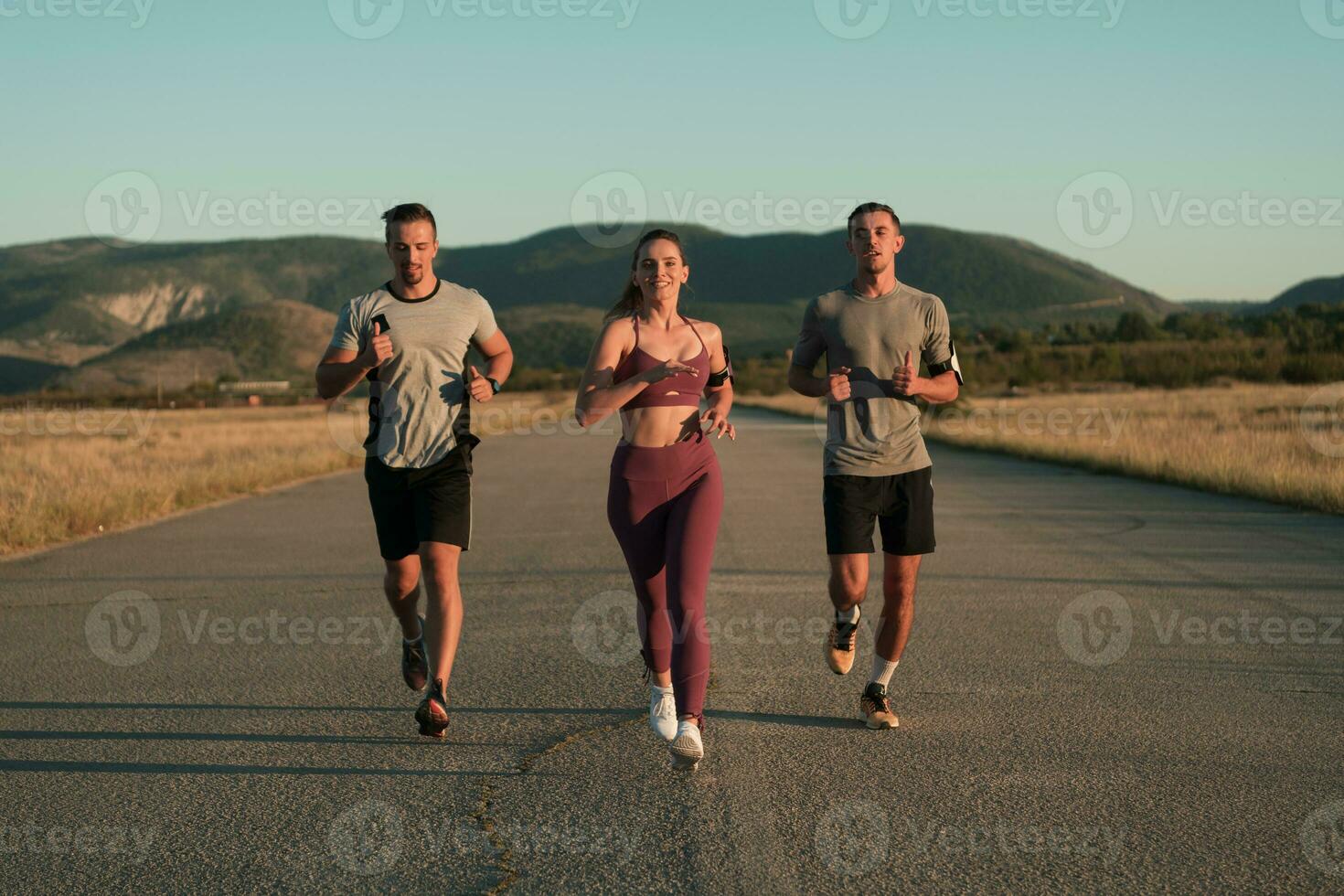 Three runners sprinting outdoors - Sportive people training in a urban area, healthy lifestyle and sport concepts photo