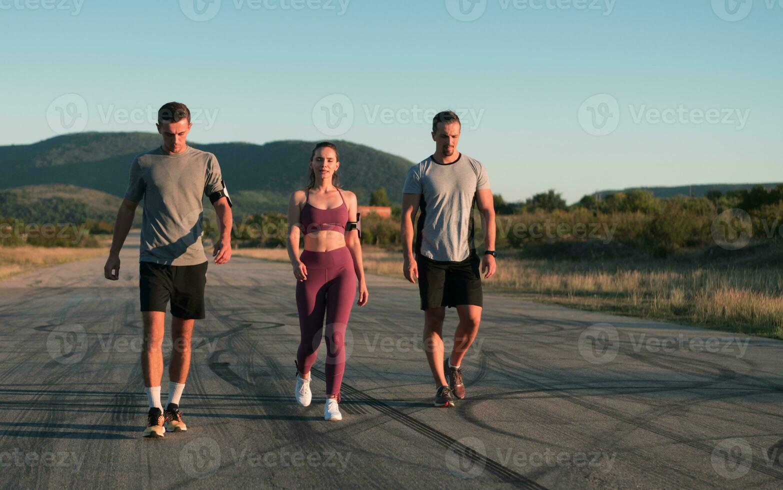 Three runners sprinting outdoors - Sportive people training in a urban area, healthy lifestyle and sport concepts photo