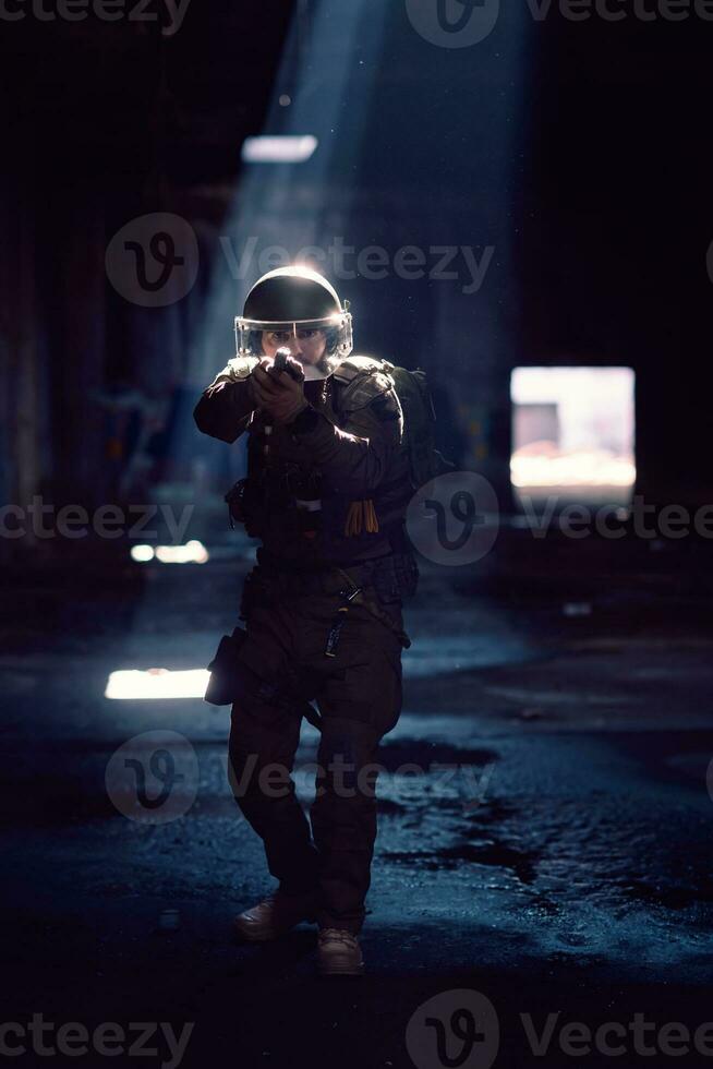 Soldier of army elite forces, special security service fighter with hidden behind mask and glasses face, in helmet and load carriage system, aiming with service pistol low key. photo