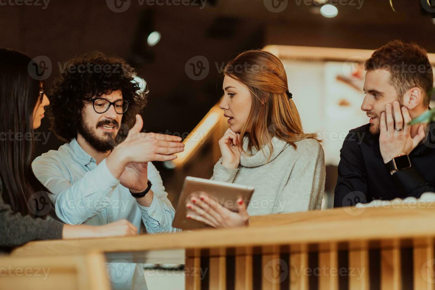 A group of people on a coffee break use laptops, tablets and smartphones while discussing new business projects. business concept. photo