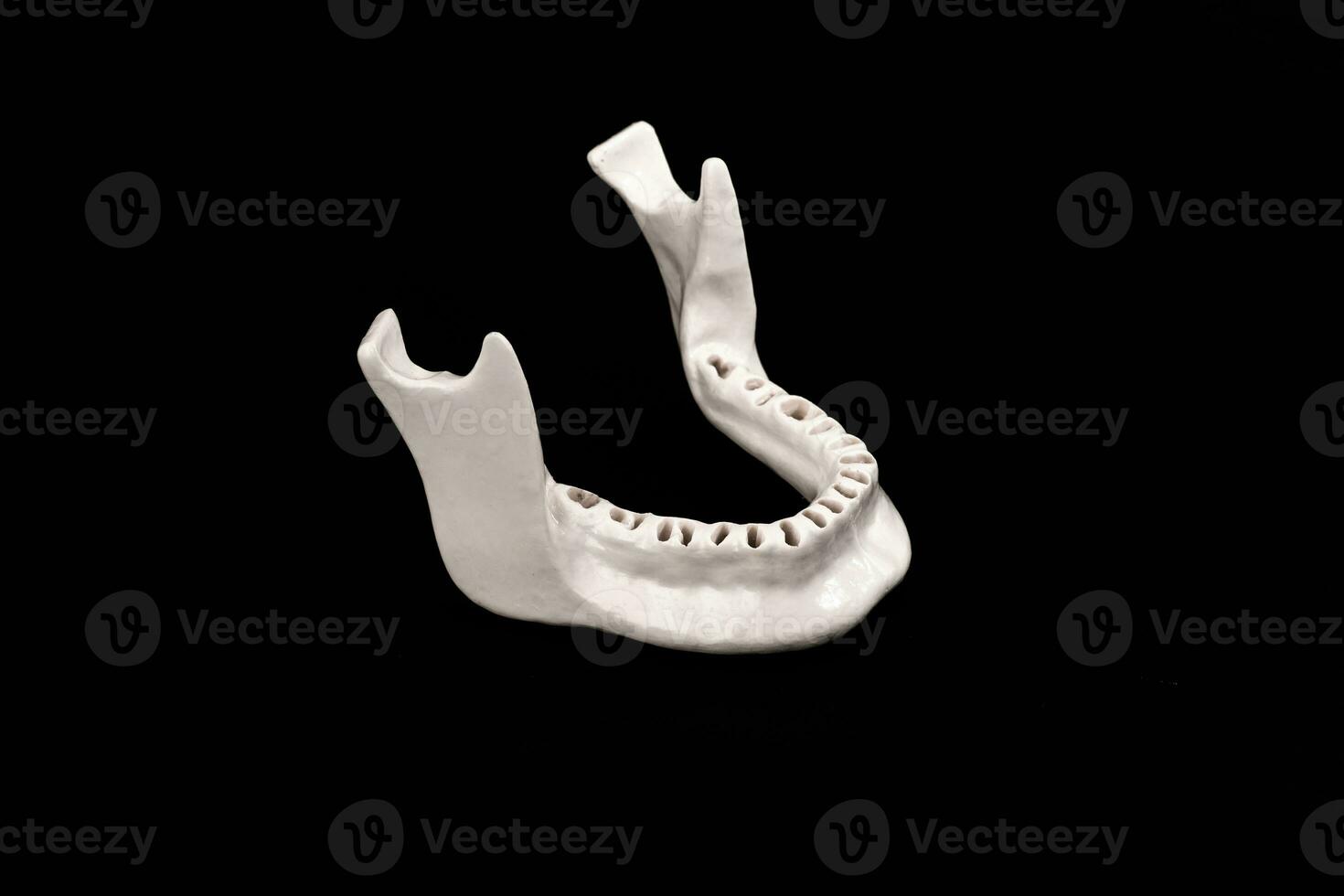 Upper human jaw without teeth model medical implant isolated on black background. Healthy teeth, dental care and orthodontic concept. photo