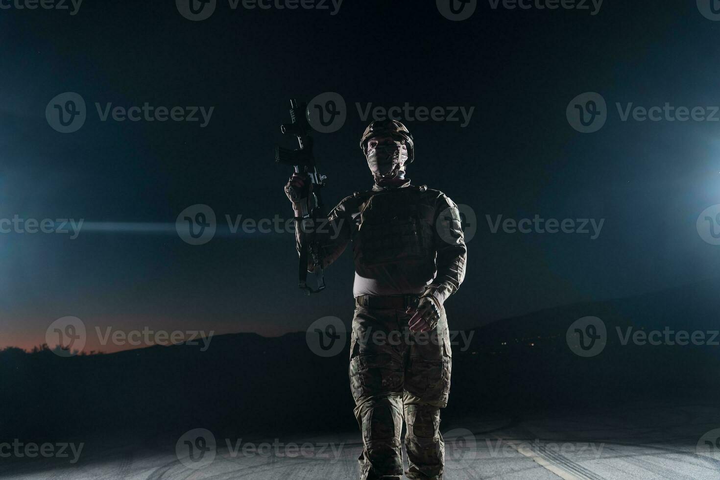 Ejército soldado en combate uniformes con un asalto rifle, plato portador y combate casco yendo en un peligroso misión en un lluvioso noche. foto