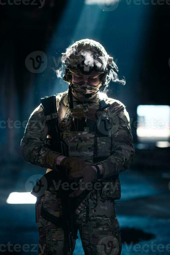 Ejército soldado en combate uniformes con un asalto rifle y combate casco noche misión oscuro antecedentes. azul y púrpura gel ligero efecto. foto