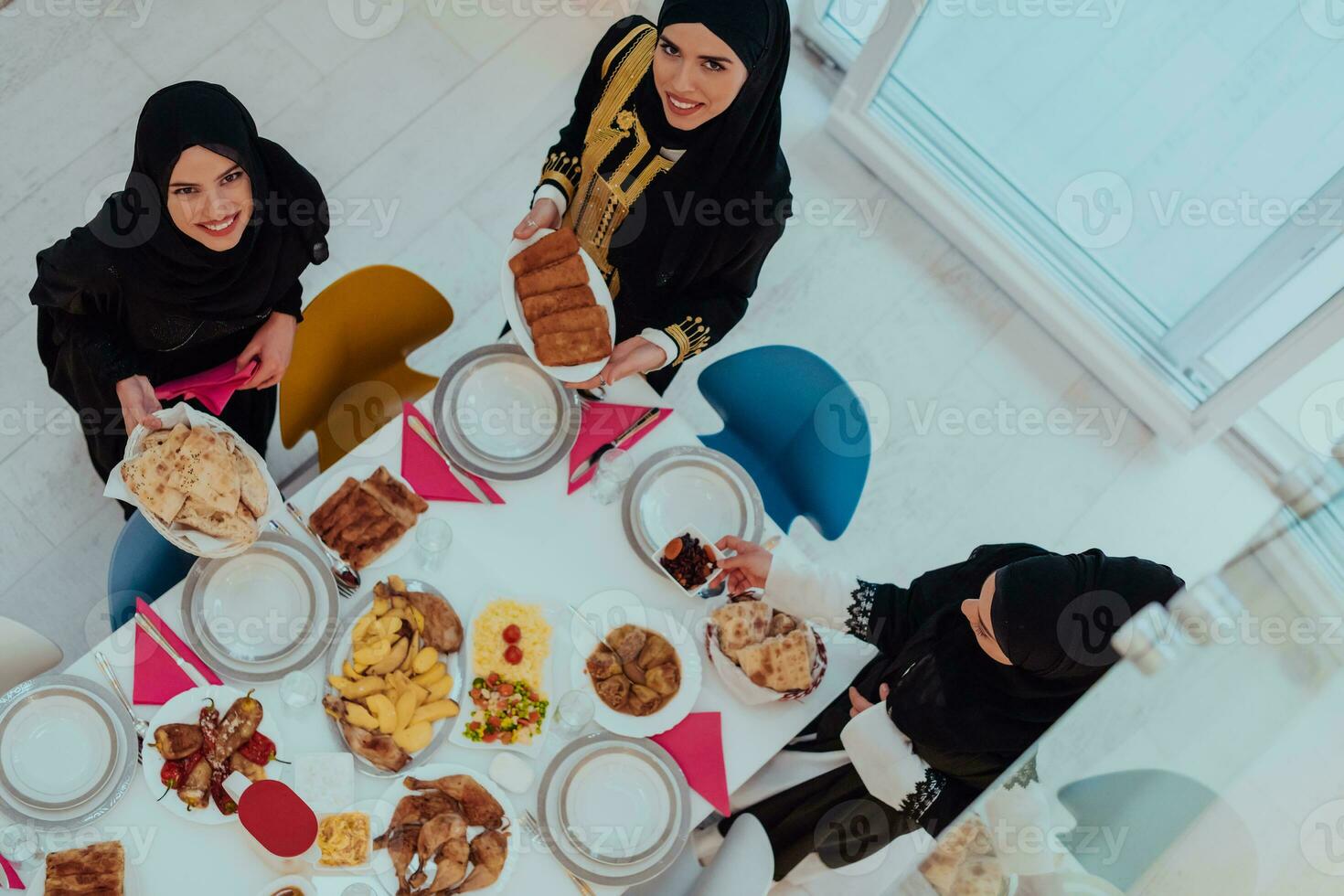 Top view of Muslim family having Iftar dinner drinking water to break feast. Eating traditional food during Ramadan feasting month at home. The Islamic Halal Eating and Drinking in modern home photo