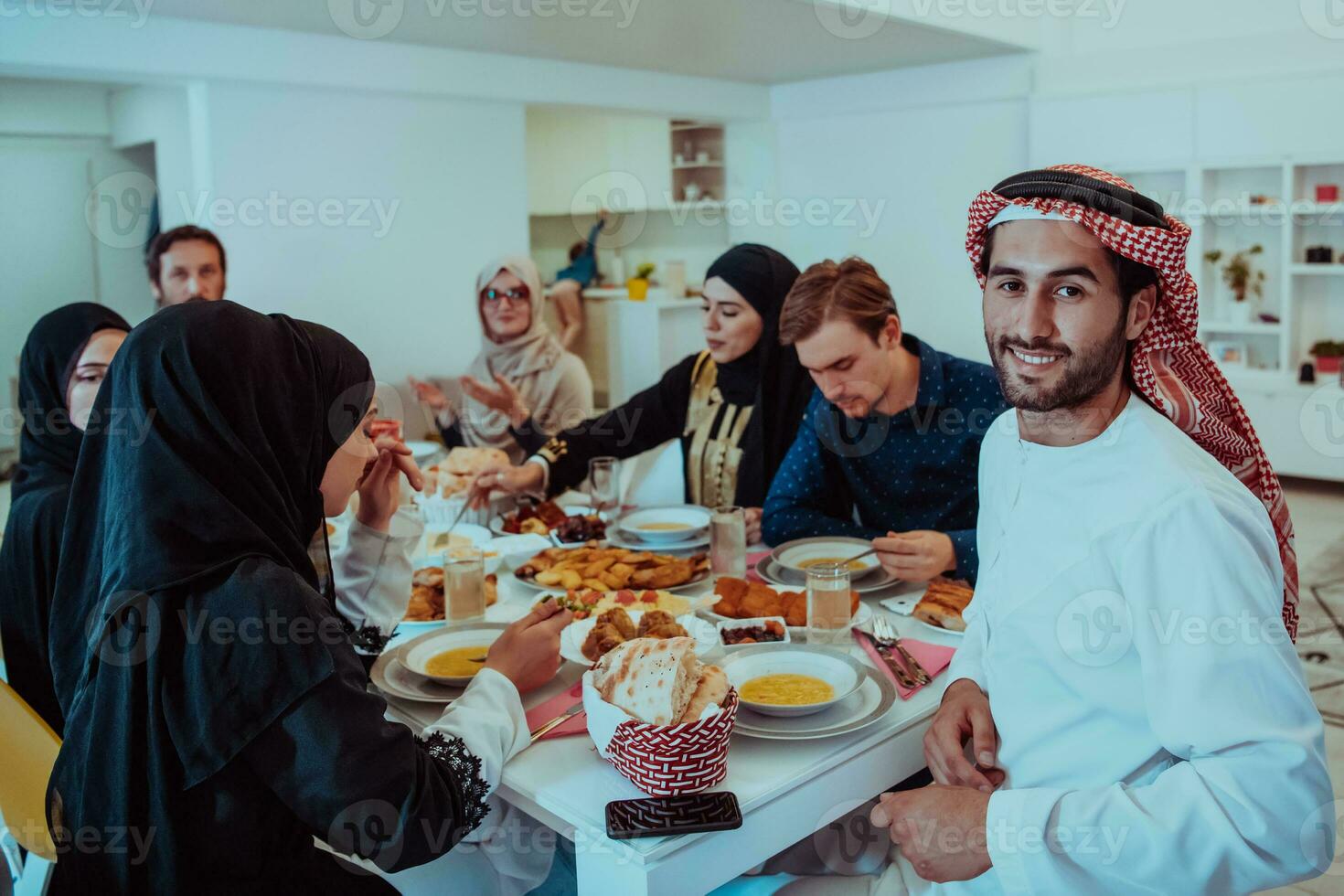 Muslim family having Iftar dinner drinking water to break feast. Eating traditional food during Ramadan feasting month at home. The Islamic Halal Eating and Drinking in modern home photo