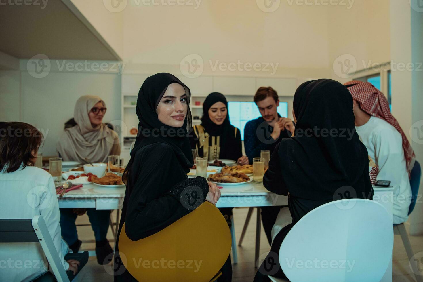 Eid Mubarak Muslim family having Iftar dinner taking pictures with smartphone while eating traditional food during Ramadan feasting month at home. The Islamic Halal Eating and Drinking Islamic family photo