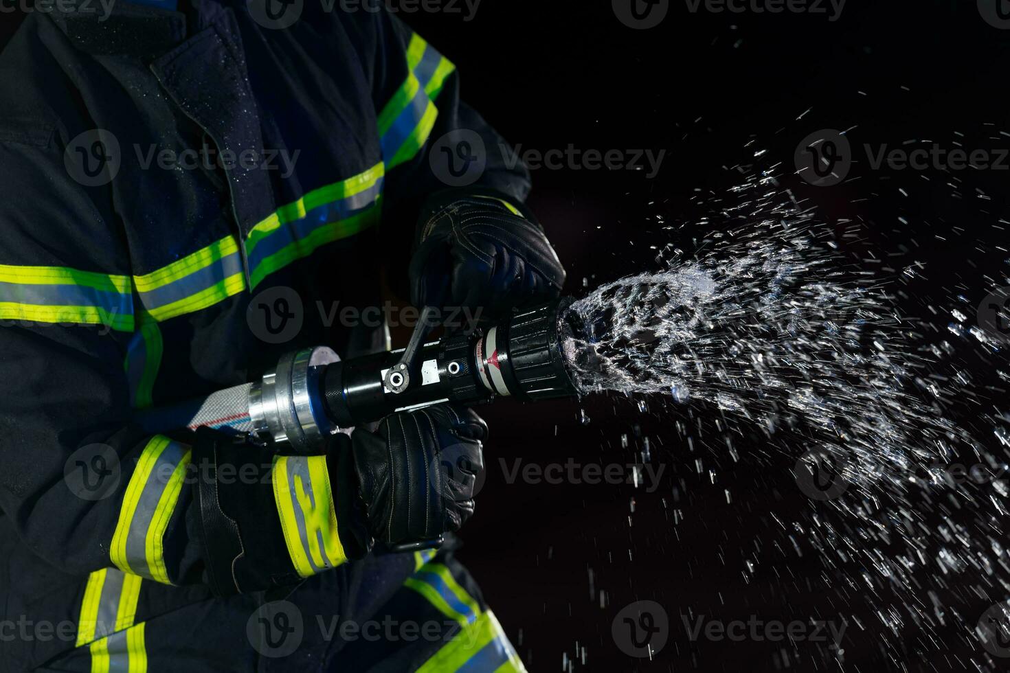 Firefighters use a water hose to eliminate a fire hazard. Team of firemen in the dangerous rescue mission. photo