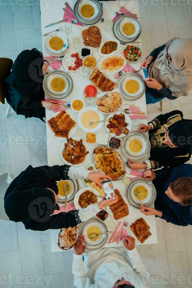 parte superior ver de musulmán familia teniendo iftar cena Bebiendo agua a descanso banquete. comiendo tradicional comida durante Ramadán banquete mes a hogar. el islámico halal comiendo y Bebiendo en moderno hogar foto