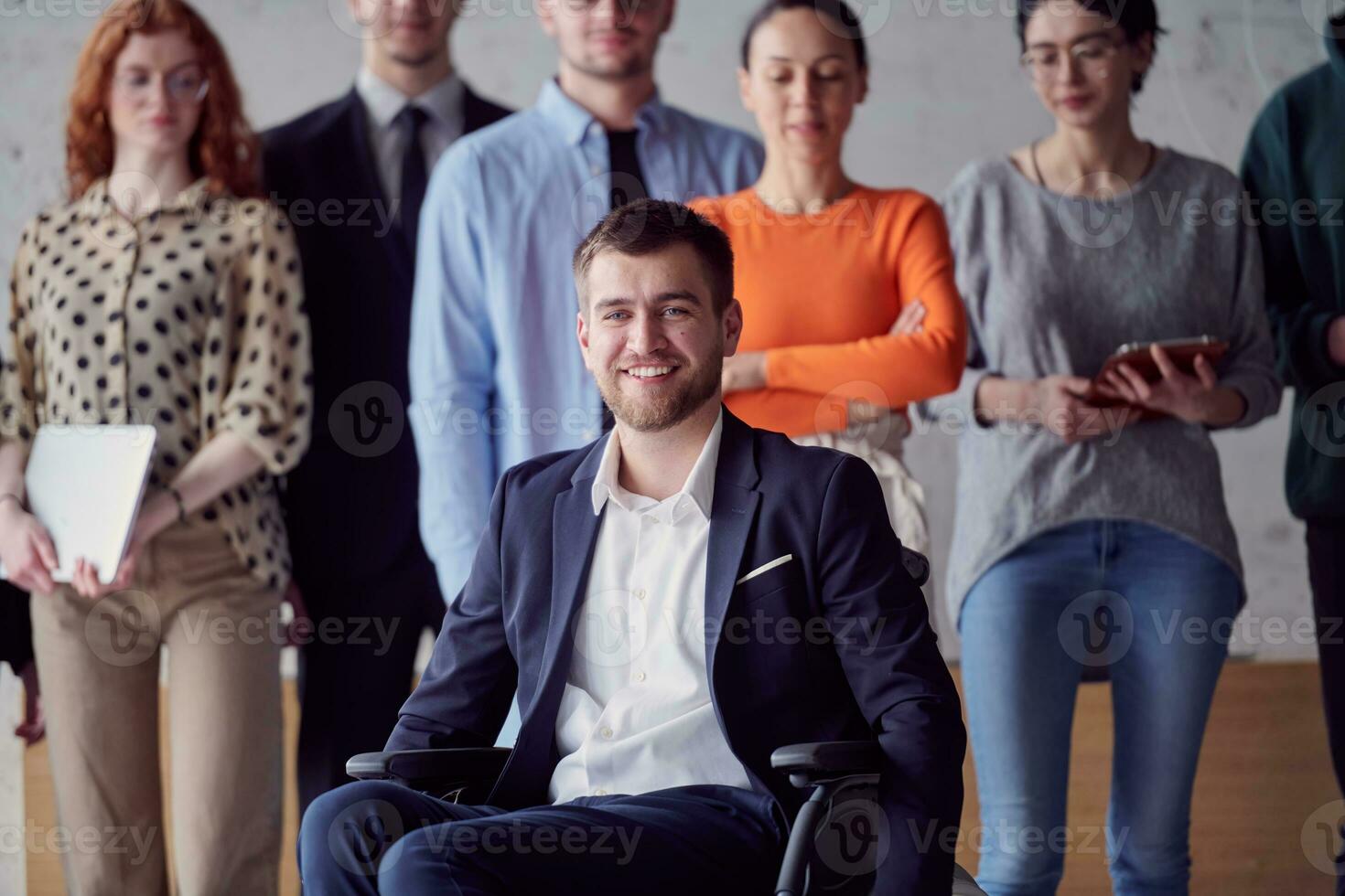 diverso grupo de negocio gente, incluso un empresario en un silla de ruedas en un moderno oficina foto