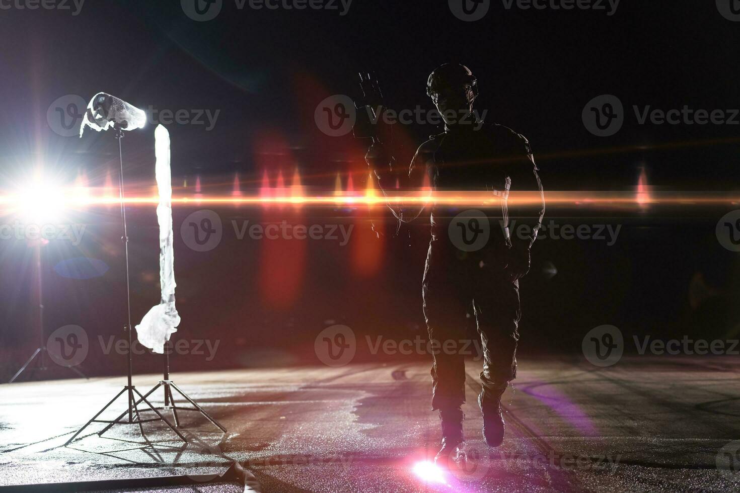 Ejército soldado en combate uniformes con un asalto rifle, plato portador y combate casco yendo en un peligroso misión en un lluvioso noche. foto