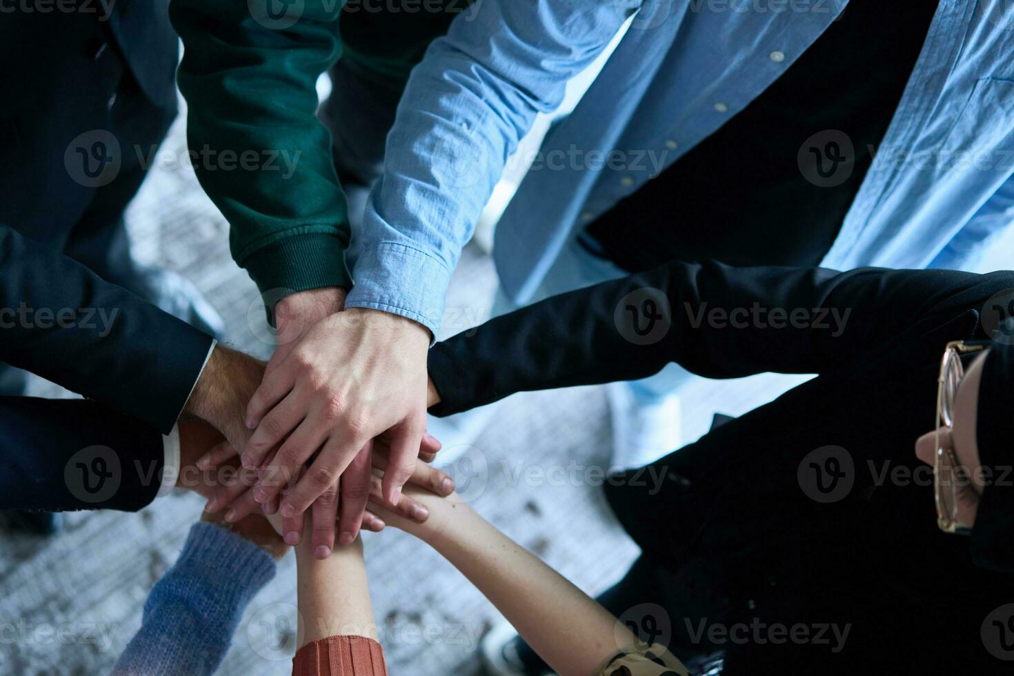 A top view photo of group of businessmen holding hands together to symbolize unity and strength