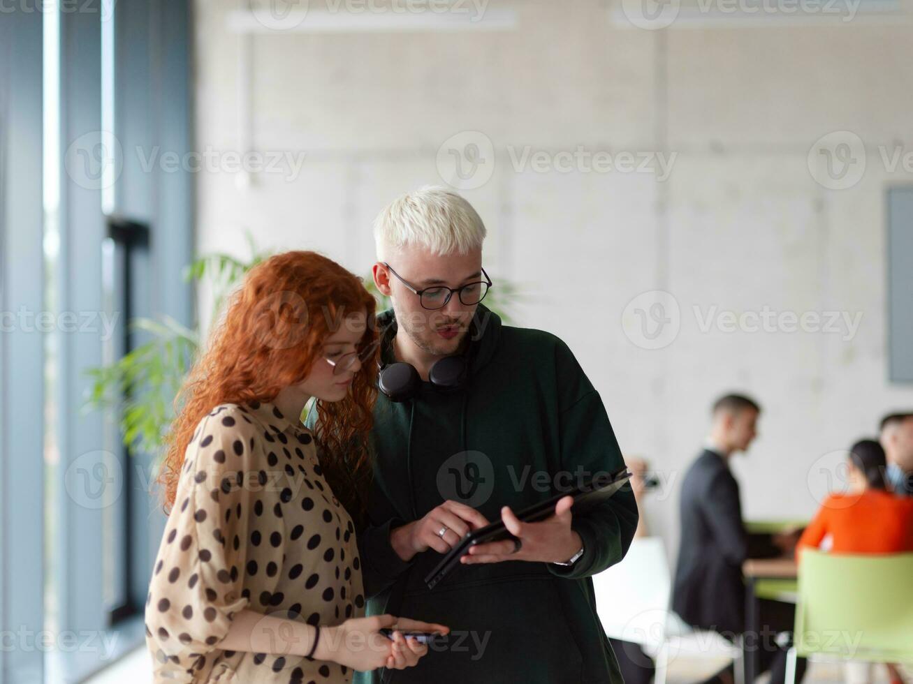 In a modern and spacious office a team of business colleagues are seen diligently working together, using a laptop to analyze data and statistics photo