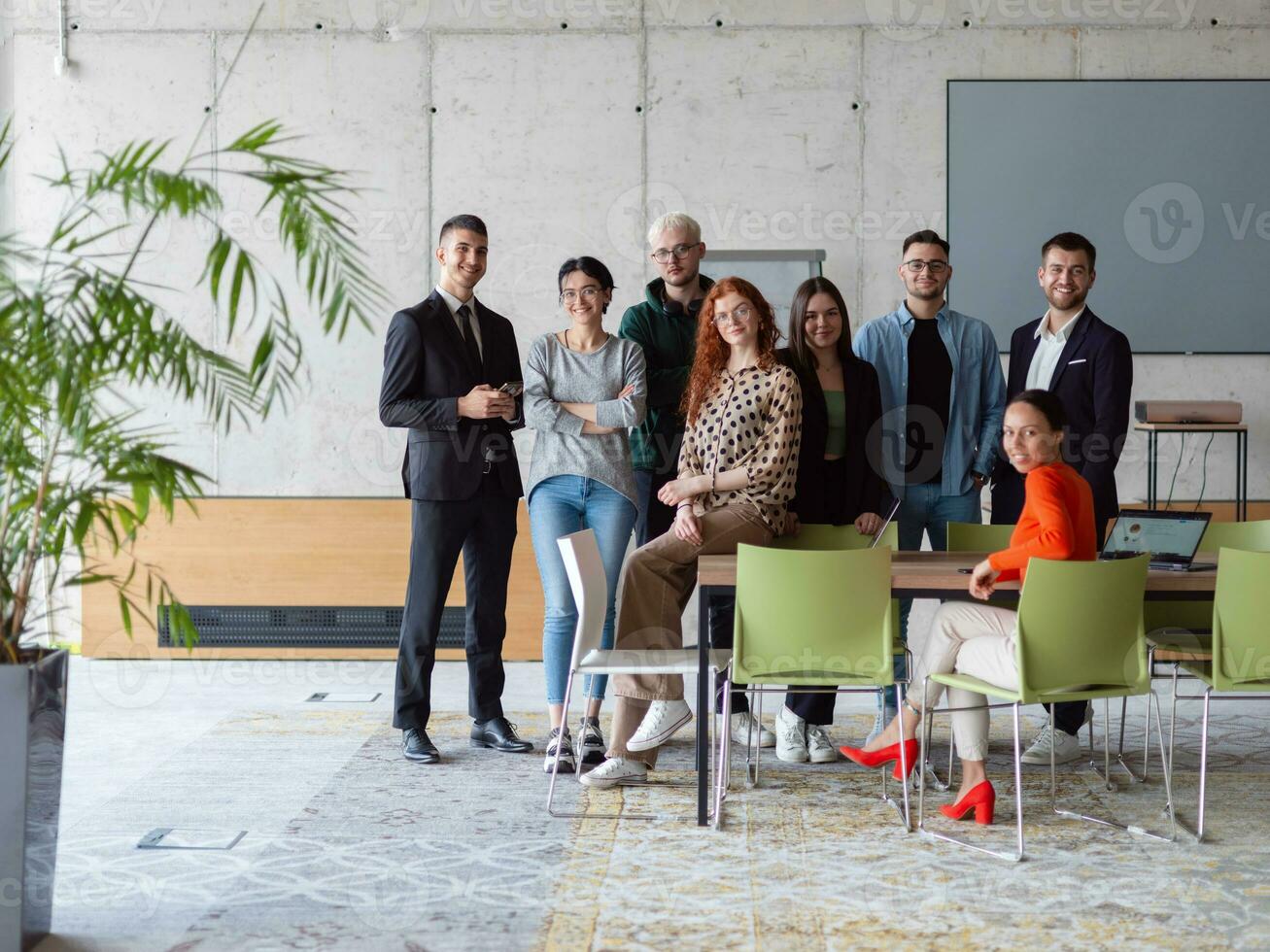 A diverse group of successful businesspeople gather and pose for a photo, showcasing teamwork and professional empowerment in a modern office setting. photo