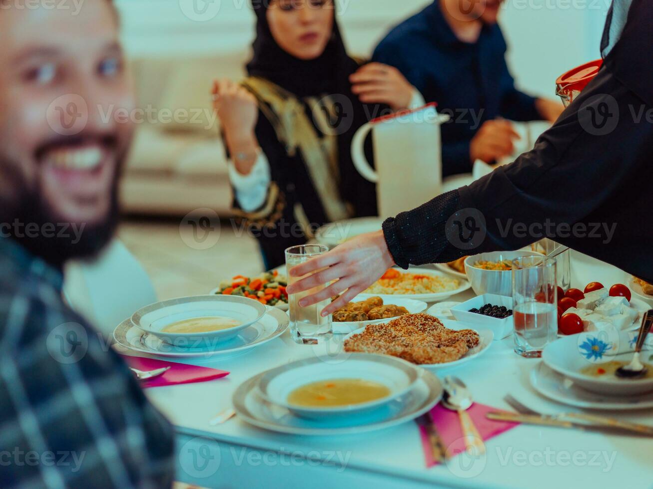 eid Mubarak musulmán familia teniendo iftar cena tomando imágenes con teléfono inteligente mientras comiendo tradicional comida durante Ramadán banquete mes a hogar. el islámico halal comiendo y Bebiendo islámico familia foto