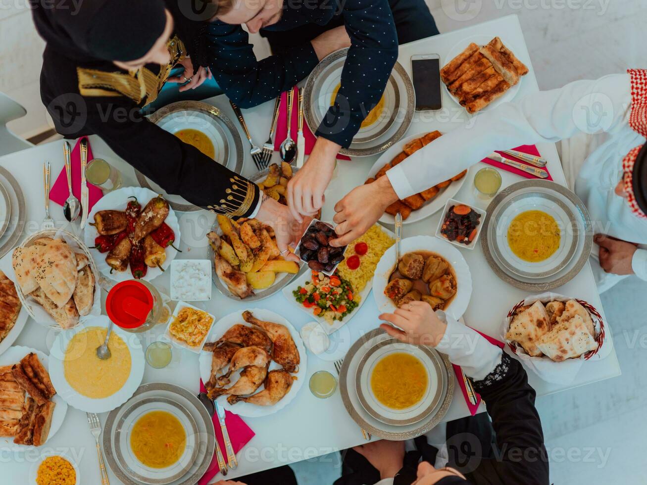 parte superior ver de musulmán familia teniendo iftar cena Bebiendo agua a descanso banquete. comiendo tradicional comida durante Ramadán banquete mes a hogar. el islámico halal comiendo y Bebiendo en moderno hogar foto