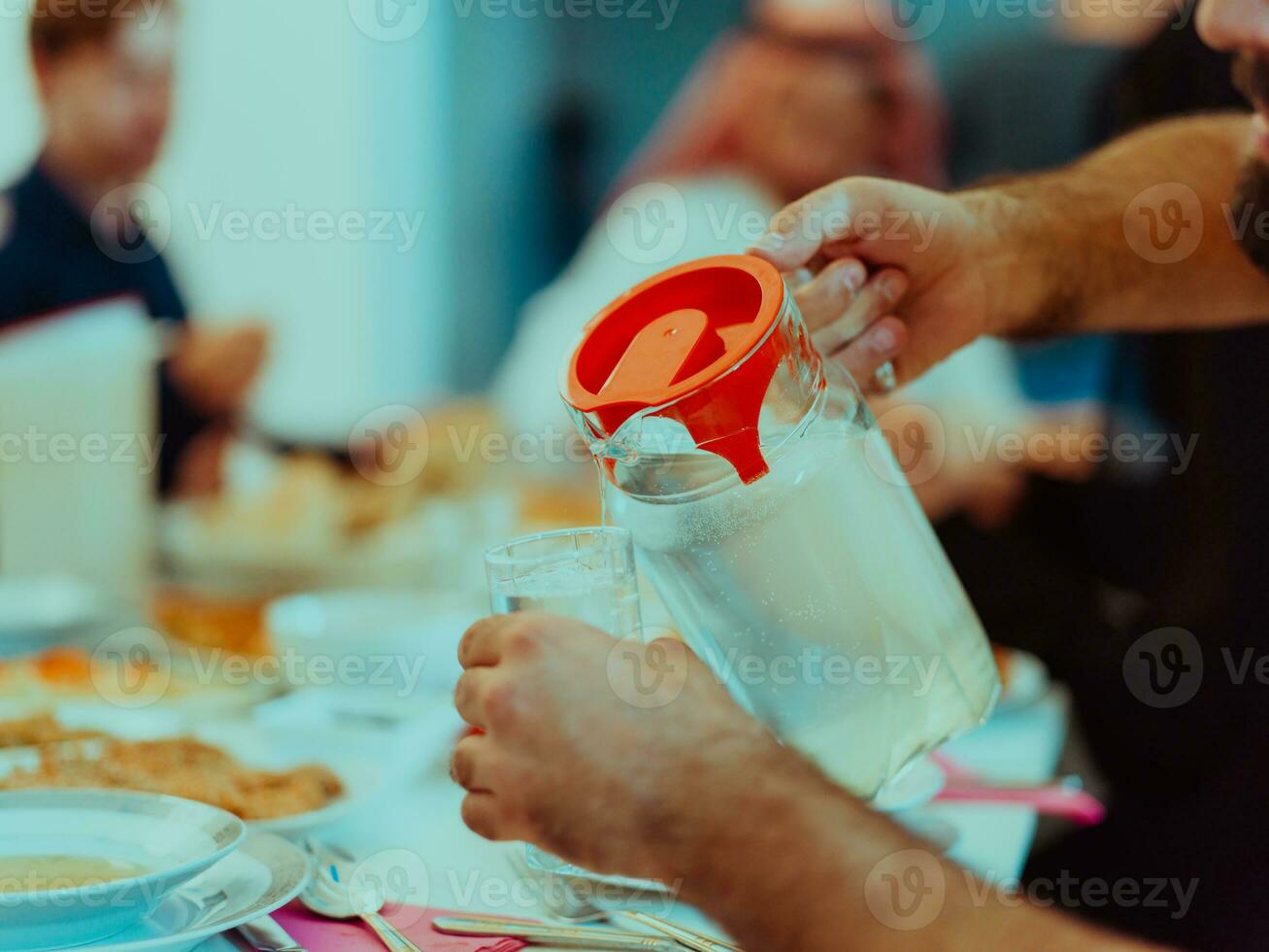 Eid Mubarak Muslim family having Iftar dinner drinking water to break feast. Eating traditional food during Ramadan feasting month at home. The Islamic Halal Eating and Drinking photo