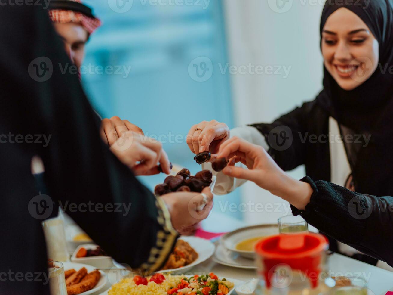 Modern multiethnic muslim family sharing a bowl of dates while enjoying iftar dinner together during a ramadan feast at home photo