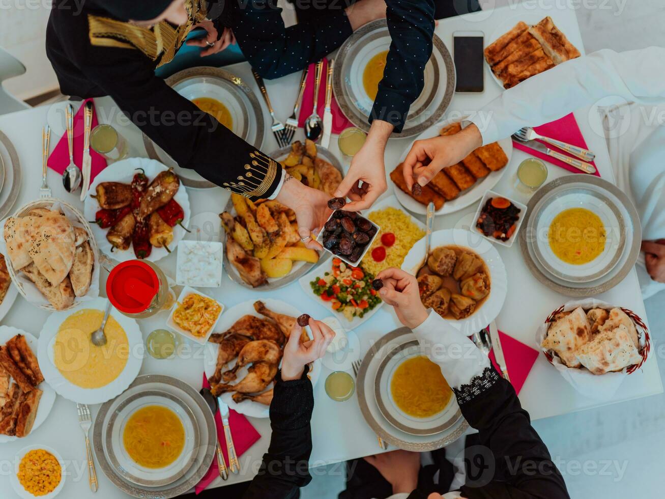 parte superior ver de musulmán familia teniendo iftar cena Bebiendo agua a descanso banquete. comiendo tradicional comida durante Ramadán banquete mes a hogar. el islámico halal comiendo y Bebiendo en moderno hogar foto