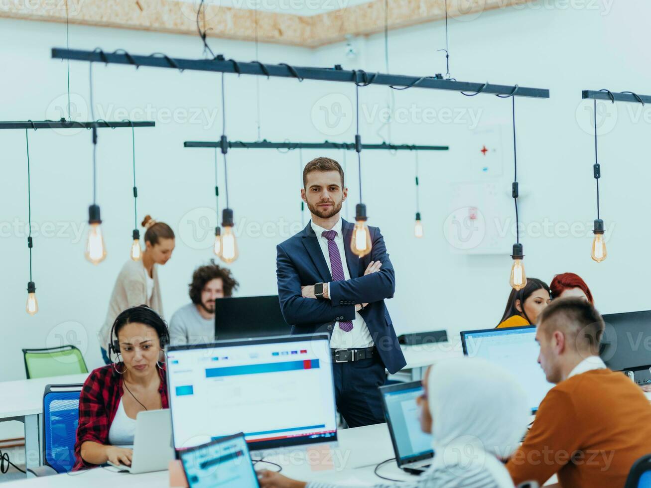 Group of multi-ethnic colleagues working on desktop computers, laptop and sharing their ideas in a modern office space.Young influencers work on online marketing projects. photo