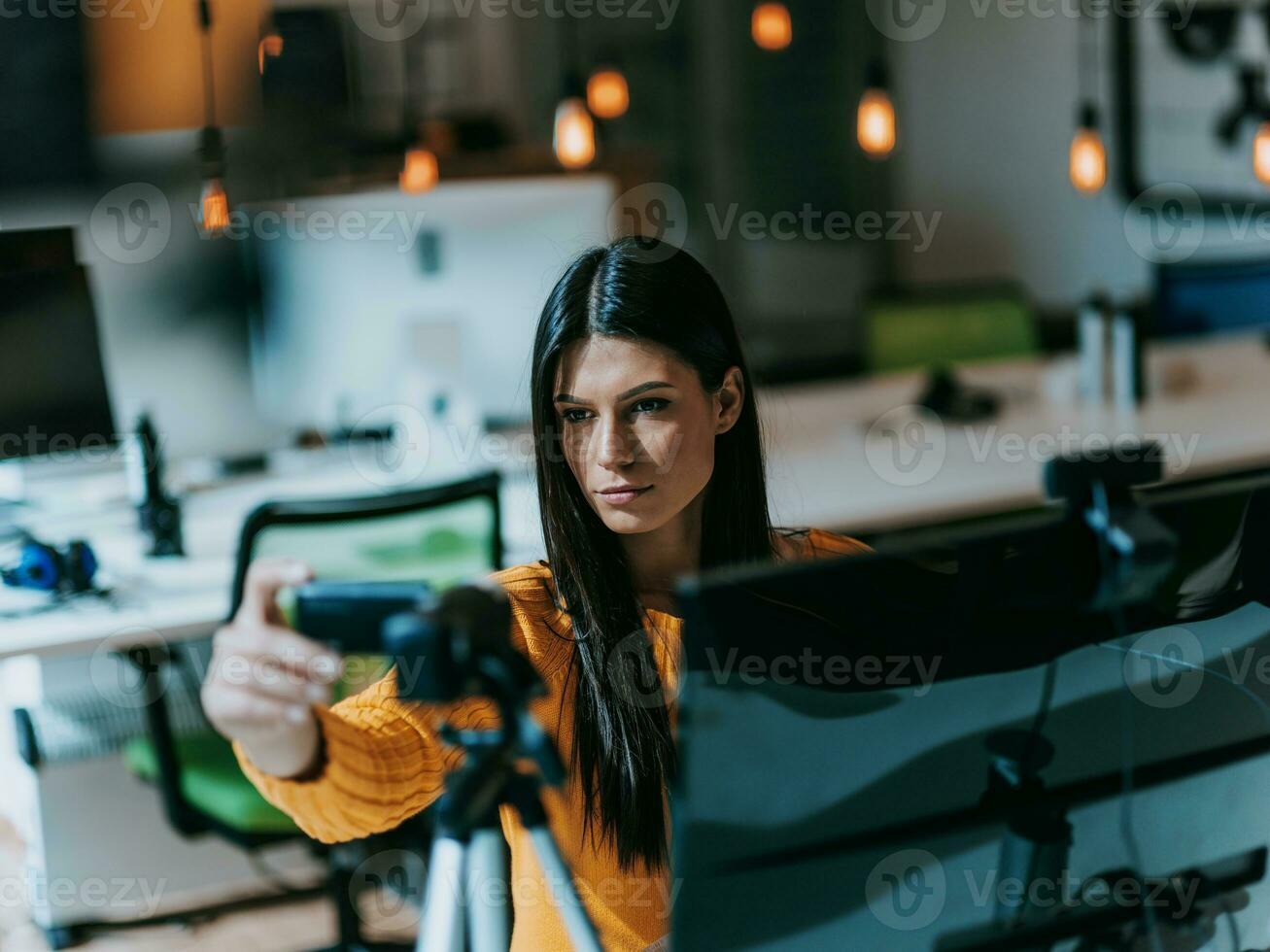 un joven mujer utilizando un cámara a presente su negocio con en línea clientela foto