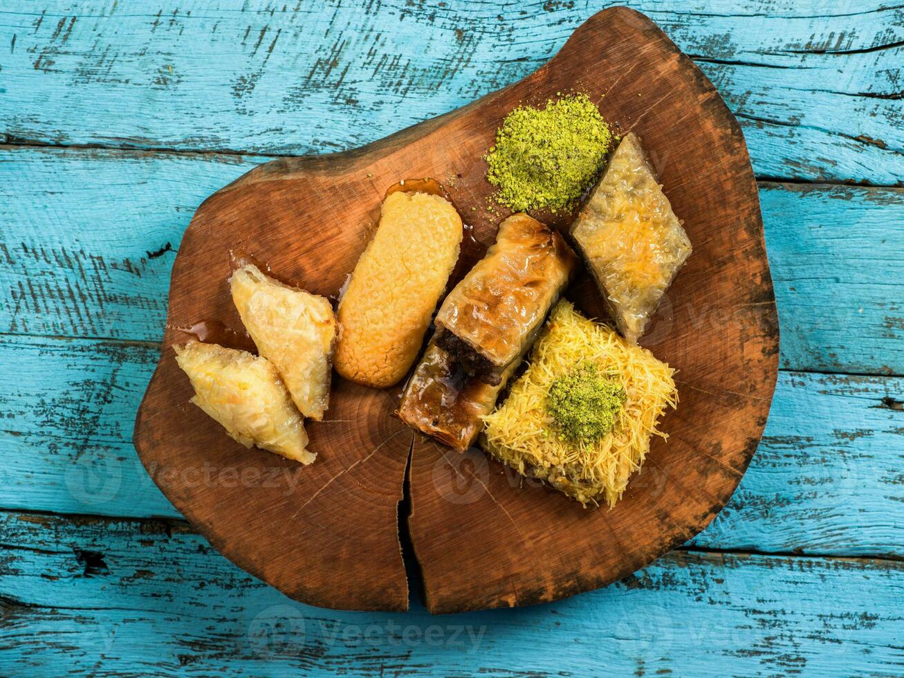 Eid Mubarak Traditional Ramadan Iftar dinner. Assorted tasty food in authentic rustic dishes on wooden blue background. Turkish Bosnian food meat kebab, pita, Sarma, klepe, sogan dolma. photo