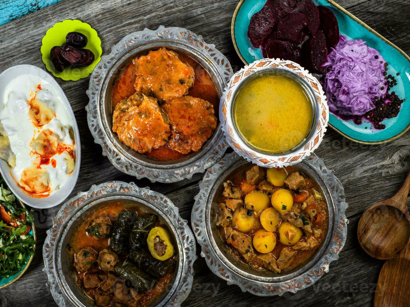 Eid Mubarak Traditional Ramadan Iftar dinner. Assorted tasty food in authentic rustic dishes on wooden blue background. Turkish Bosnian food meat kebab, pita, Sarma, klepe, sogan dolma. photo