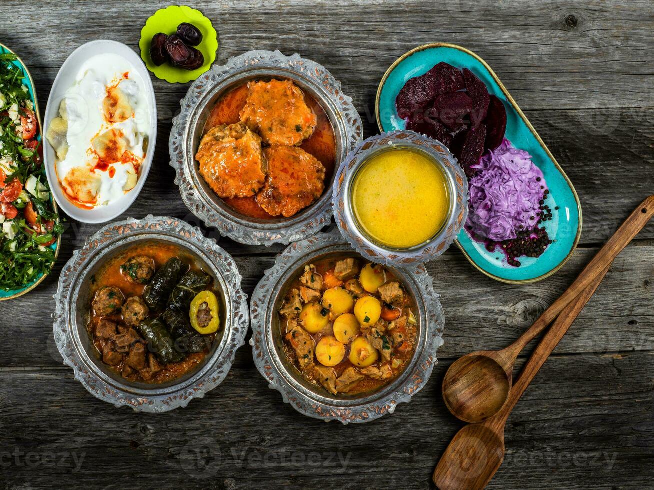 Eid Mubarak Traditional Ramadan Iftar dinner. Assorted tasty food in authentic rustic dishes on wooden blue background. Turkish Bosnian food meat kebab, pita, Sarma, klepe, sogan dolma. photo