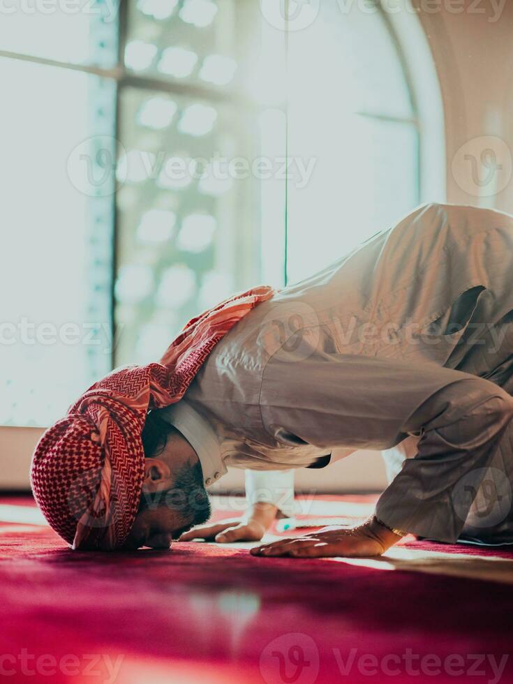 A Muslim praying in a modern mosque during the holy Muslim month of Ramadan photo
