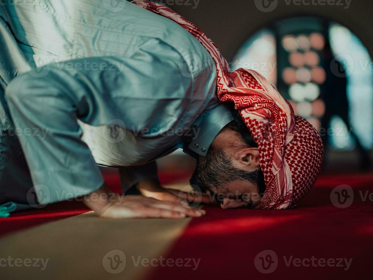 A Muslim praying in a modern mosque during the holy Muslim month of Ramadan photo