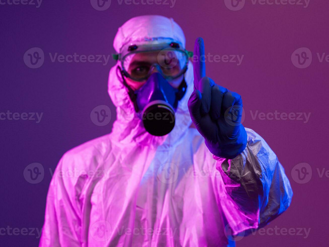 Coronavirus covid-19 pandemic. Doctor scientist wearing protective biological suit and mask due to global healthcare epidemic warning and danger background in blue and pink neon lights background. photo