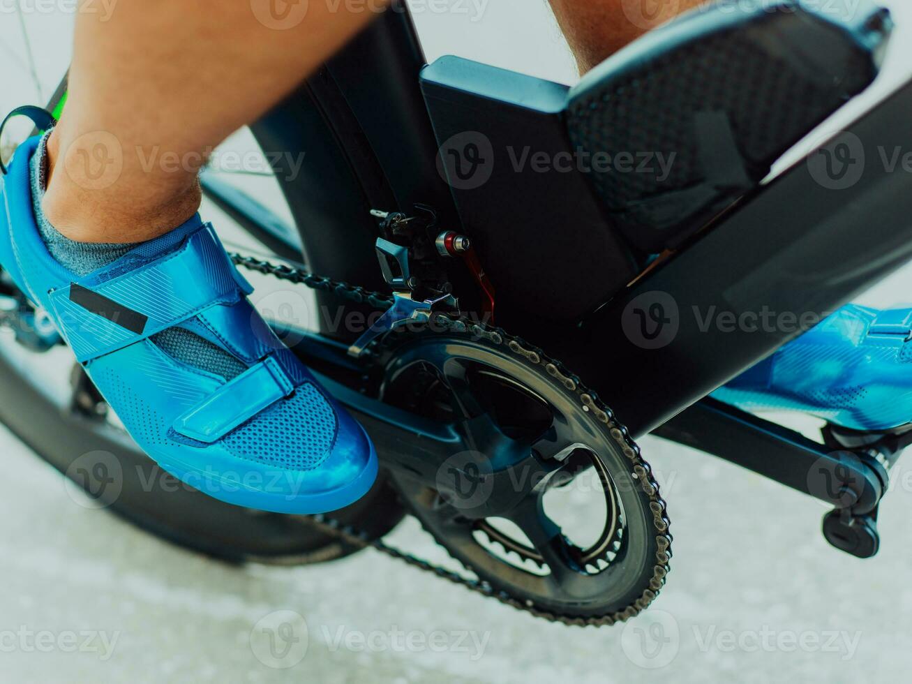 Close up photo of an active triathlete in sportswear and with a protective helmet riding a bicycle. Selective focus