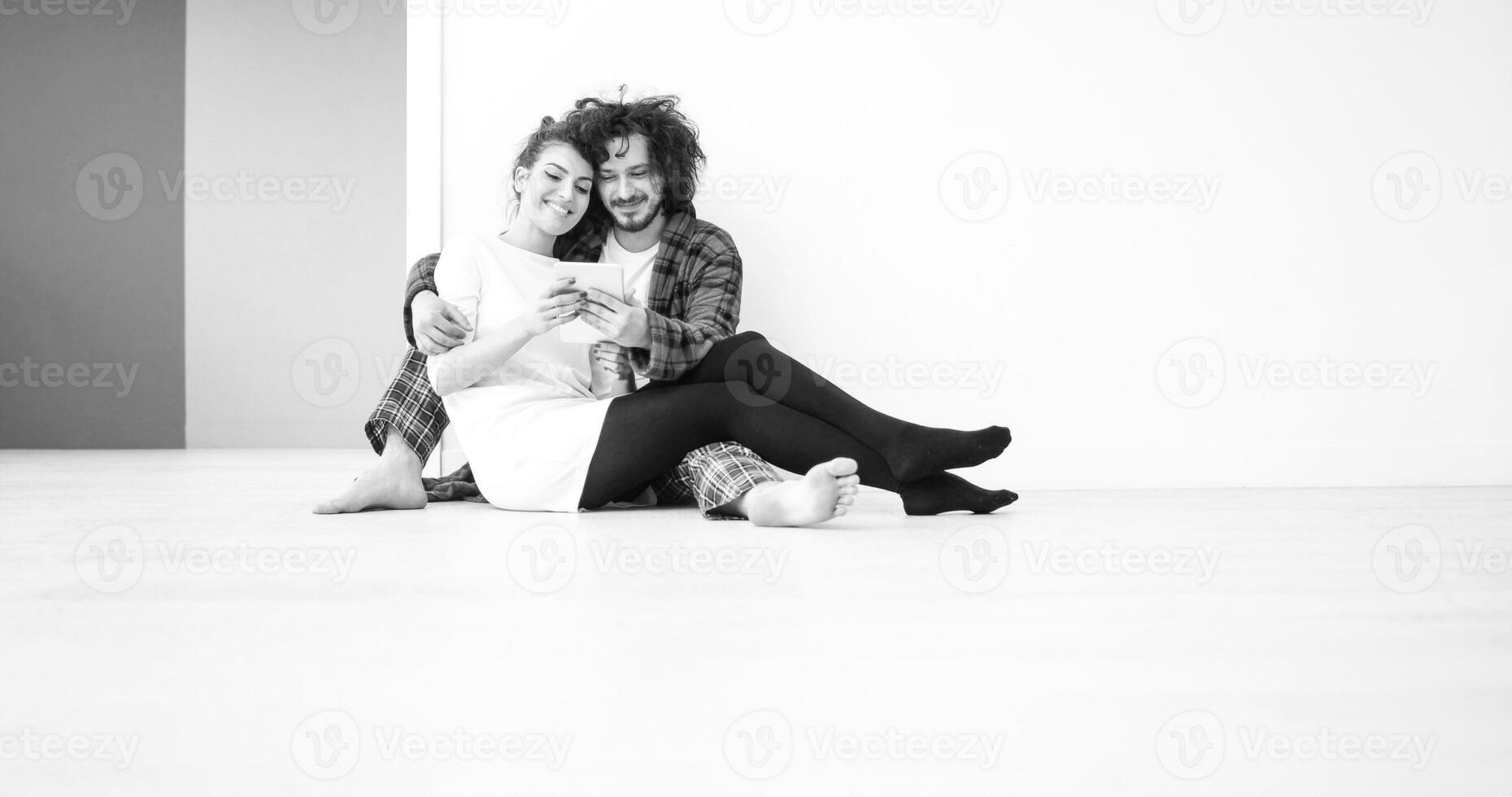 Young Couple using digital tablet on the floor photo