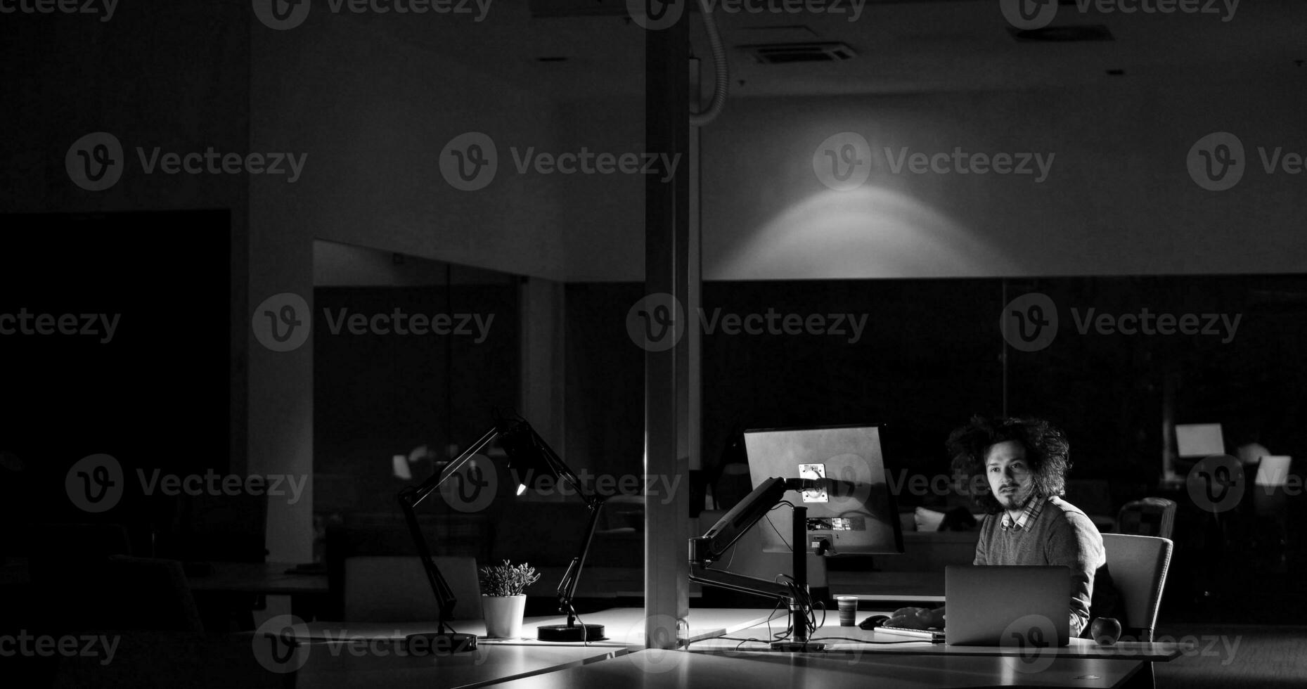 man working on computer in dark office photo