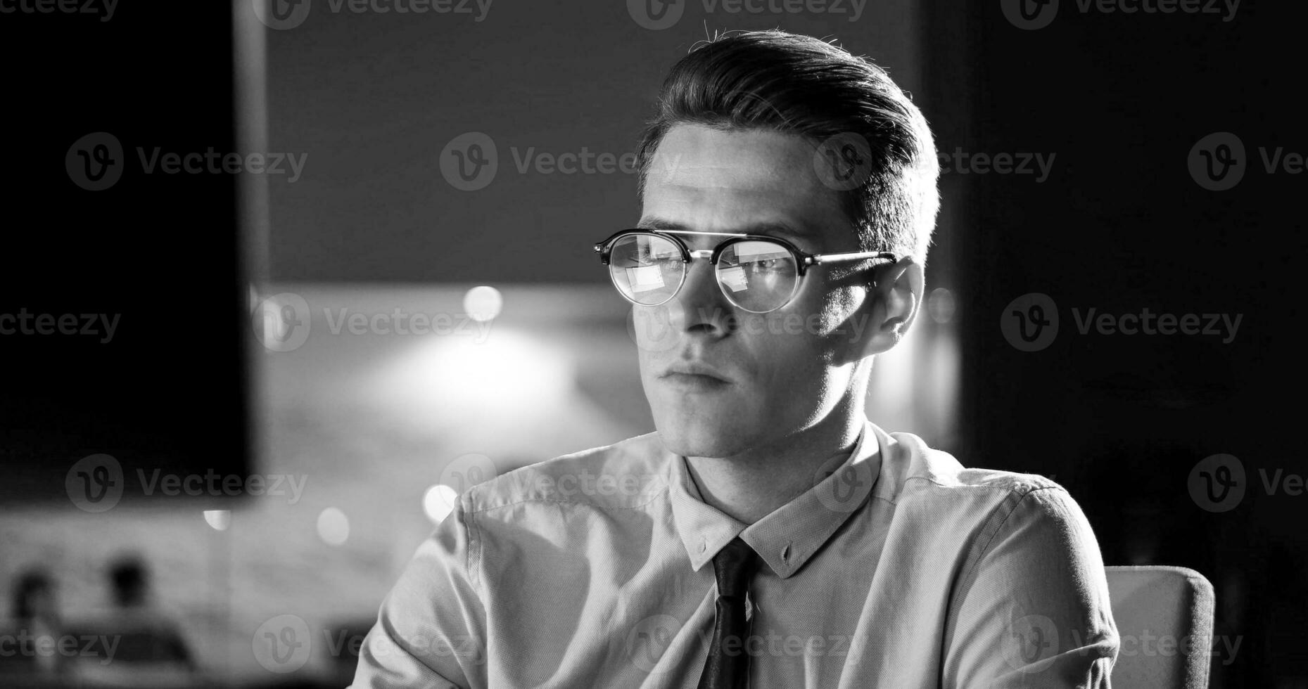 man working on computer in dark office photo