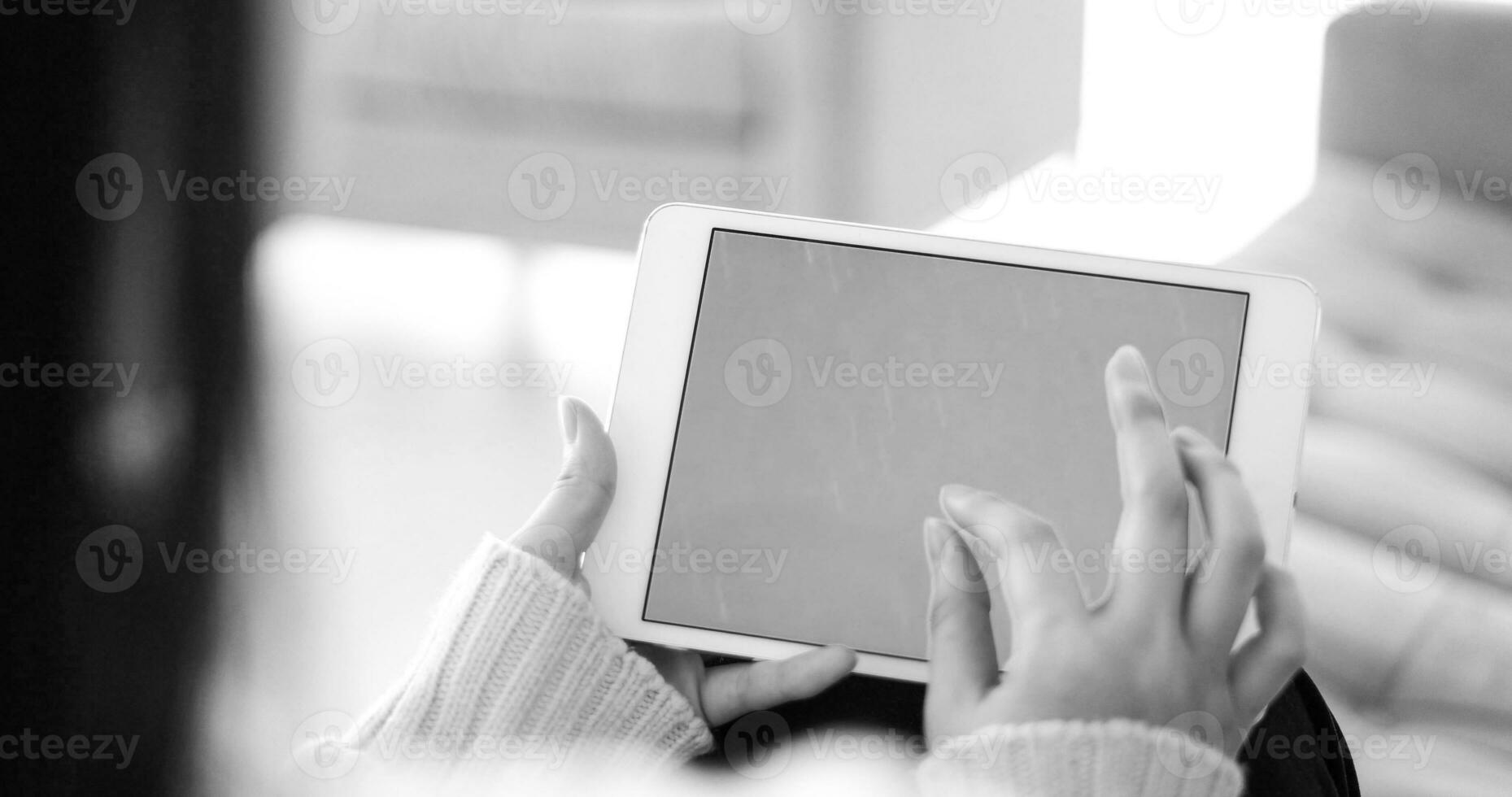 woman on sofa using tablet computer photo