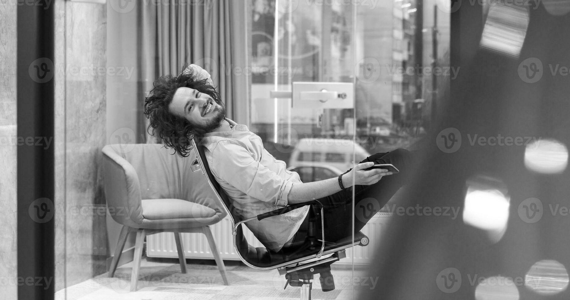 hombre de negocios sentado con las piernas en el escritorio foto
