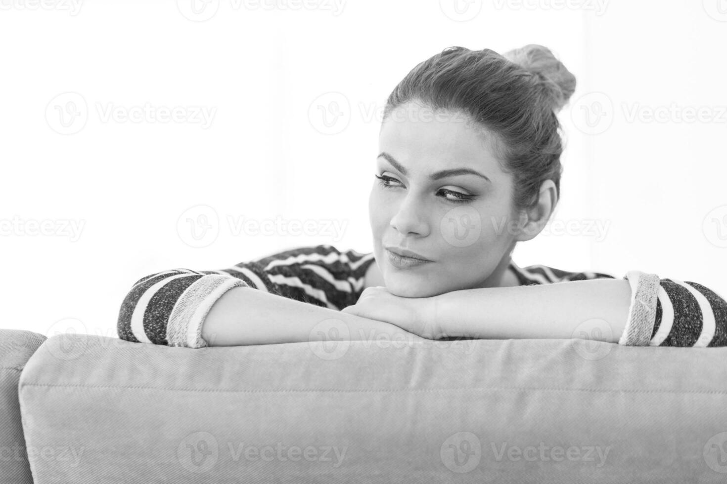 portrait of a young beautiful woman sitting on the sofa photo