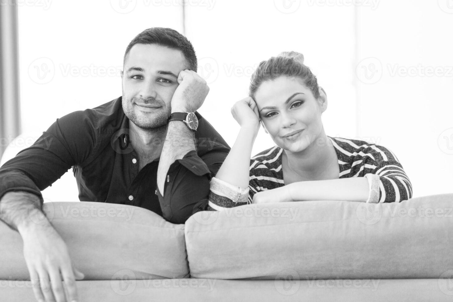 Portrait of young couple sitting on sofa photo