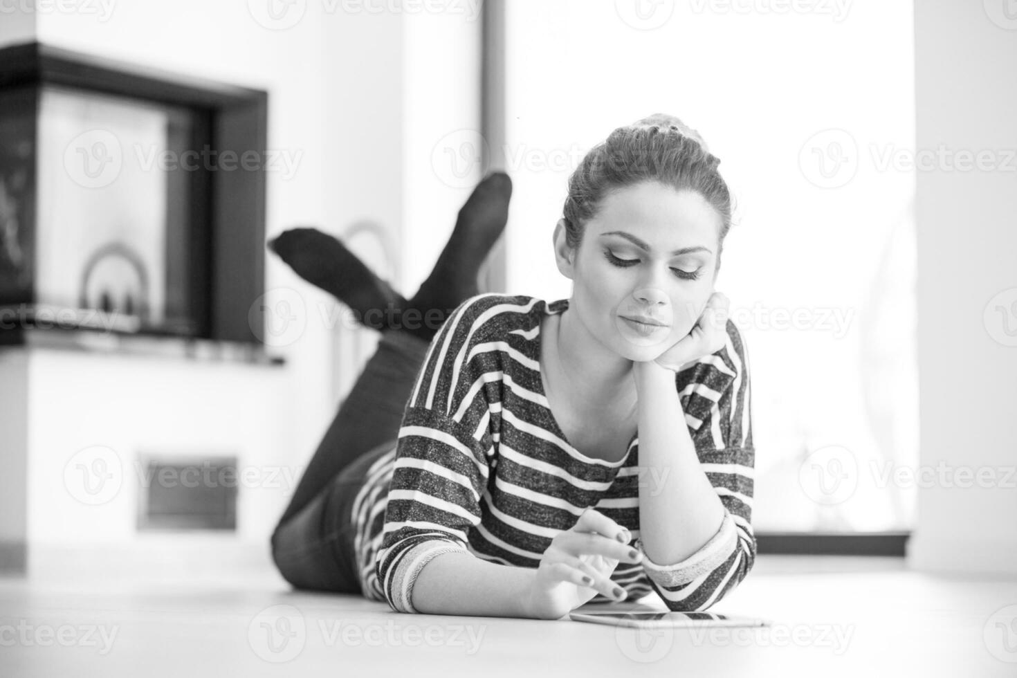 woman using tablet computer in front of fireplace photo