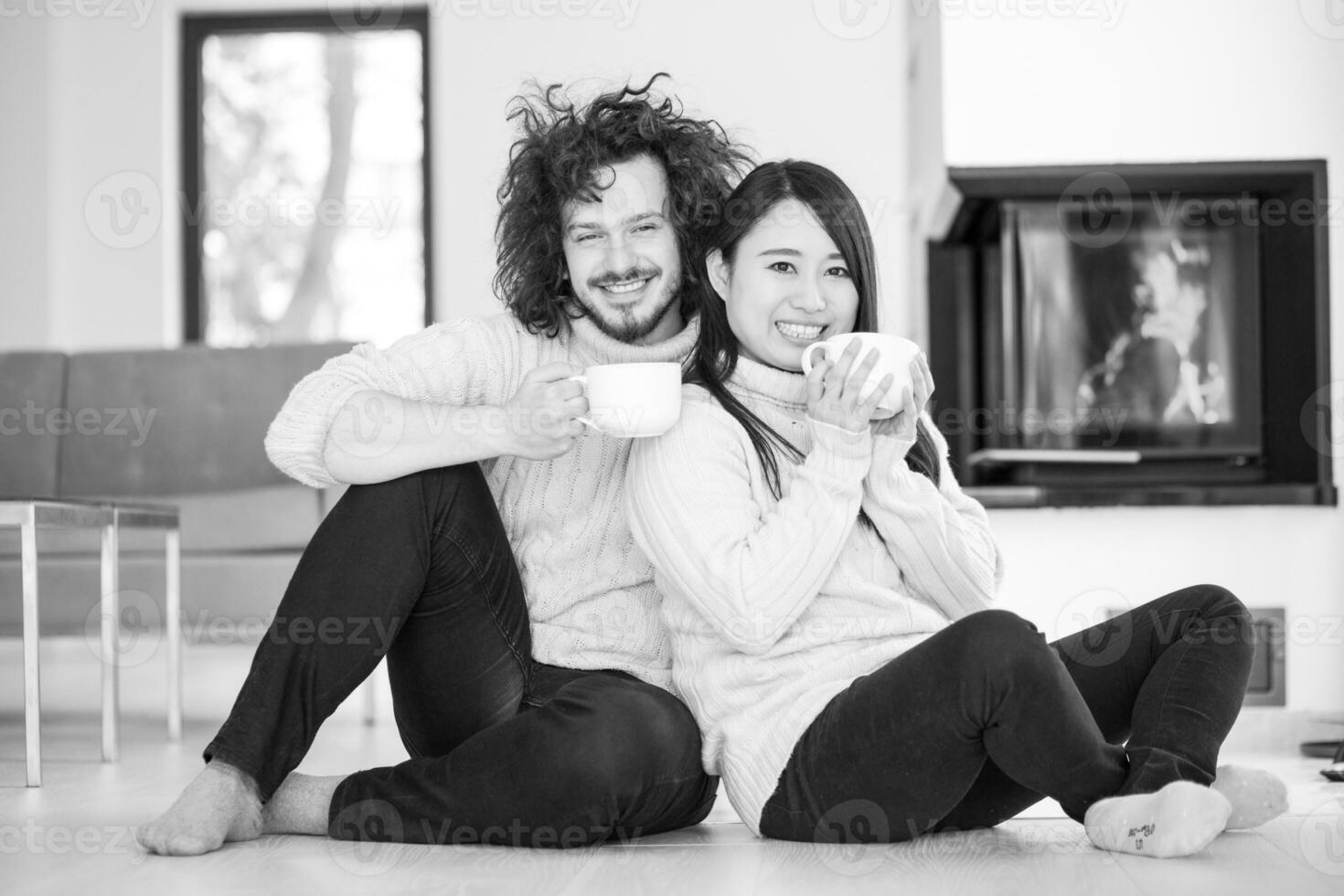 happy multiethnic couple  in front of fireplace photo