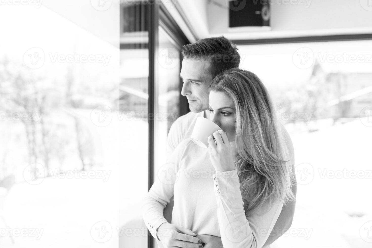 young couple enjoying morning coffee by the window photo