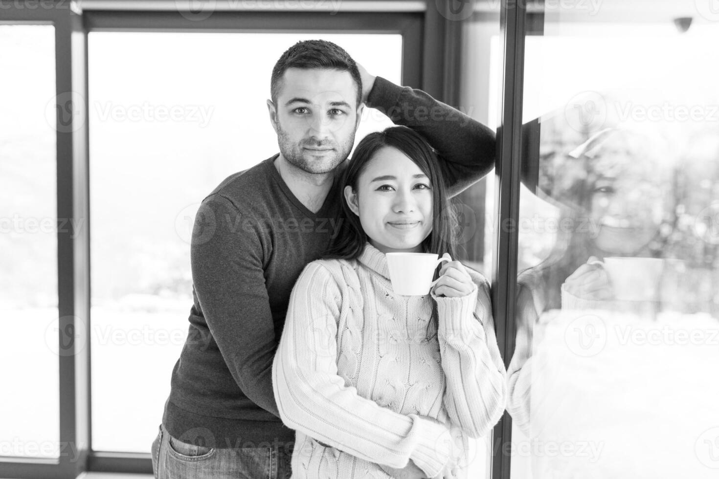 pareja multiétnica disfrutando del café matutino junto a la ventana foto