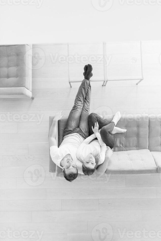 Young couple on the sofa watching television top view photo