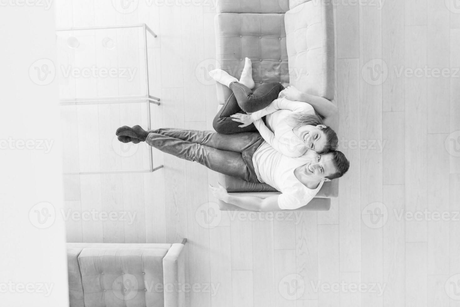 Young couple on the sofa watching television top view photo