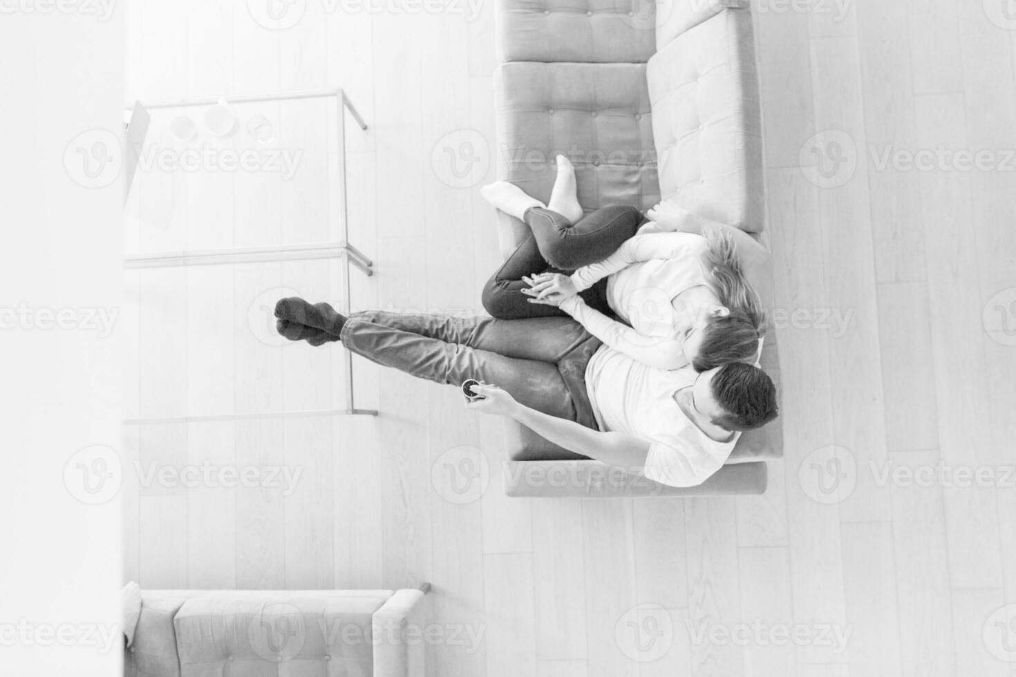 Young couple on the sofa watching television top view photo