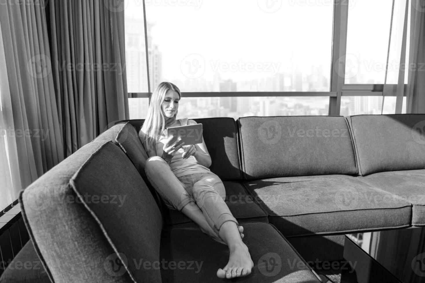 young woman on sofa at home surfing web photo