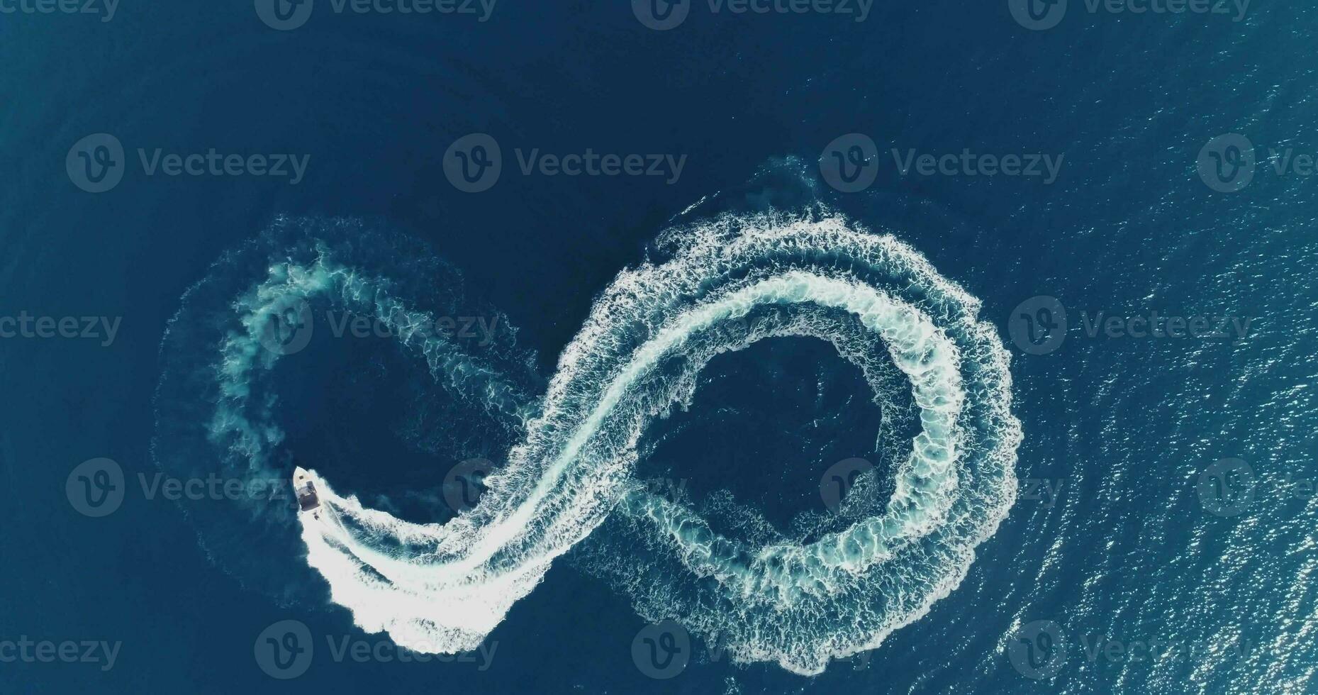 Aerial top view of a white pleasure boat on a summer day. Powerboat turn loop eight on the sea making infinity future concept. photo