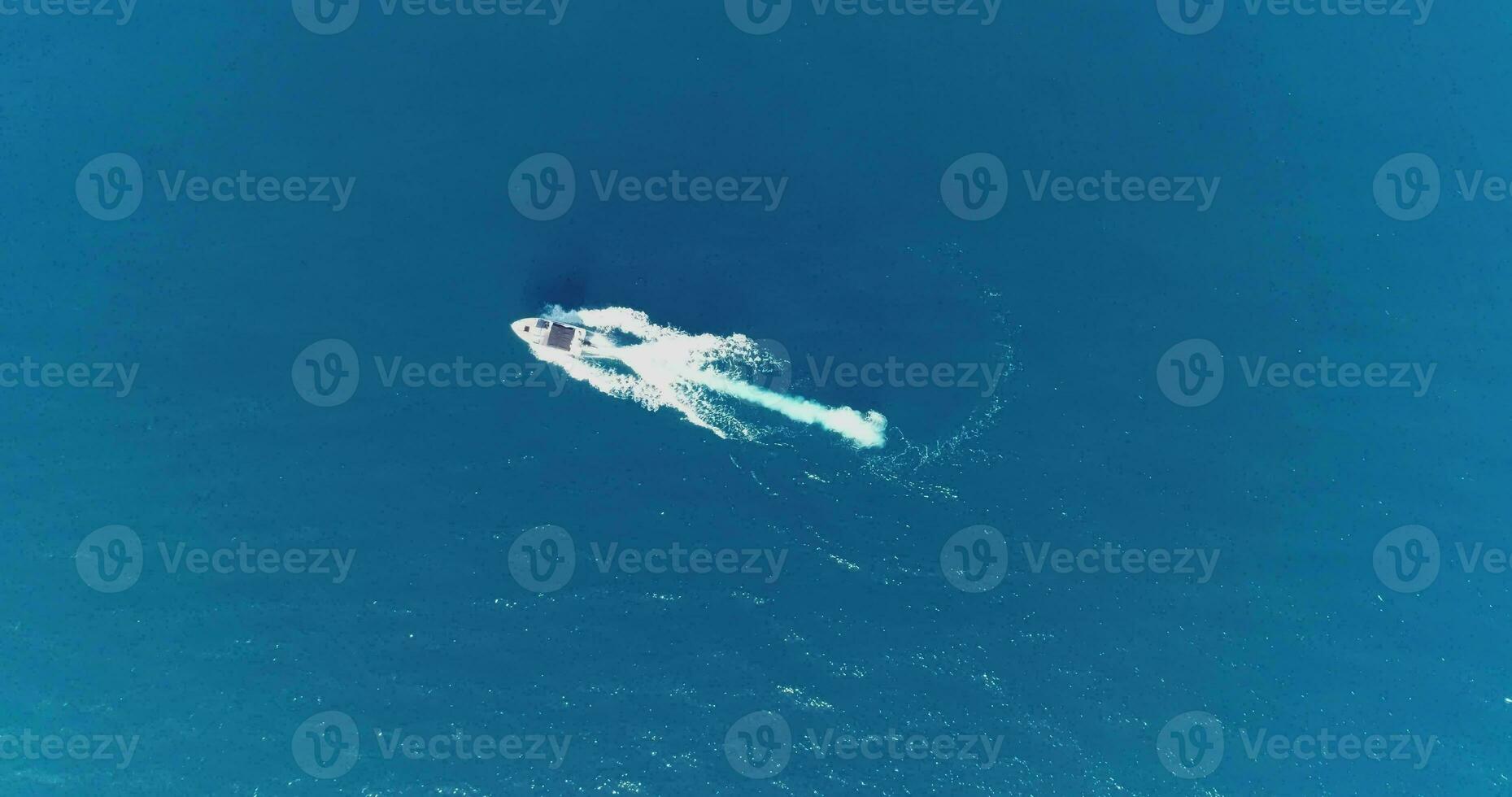 Aerial top view of a white pleasure boat on a summer day. Powerboat turn loop eight on the sea making infinity future concept. photo