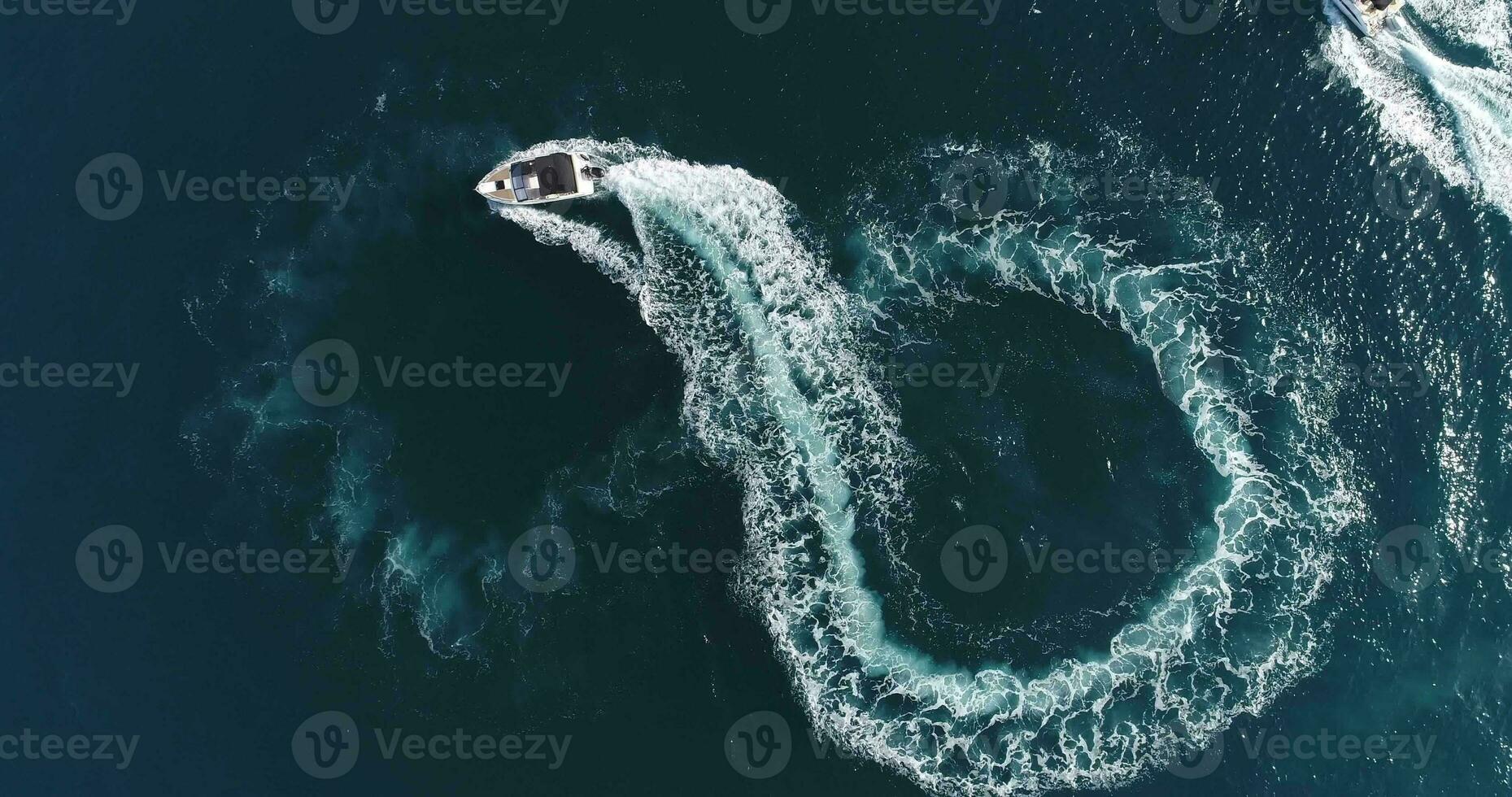 Aerial top view of a white pleasure boat on a summer day. Powerboat turn loop eight on the sea making infinity future concept. photo