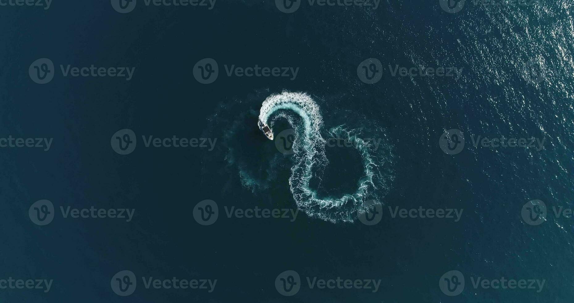 Aerial top view of a white pleasure boat on a summer day. Powerboat turn loop eight on the sea making infinity future concept. photo